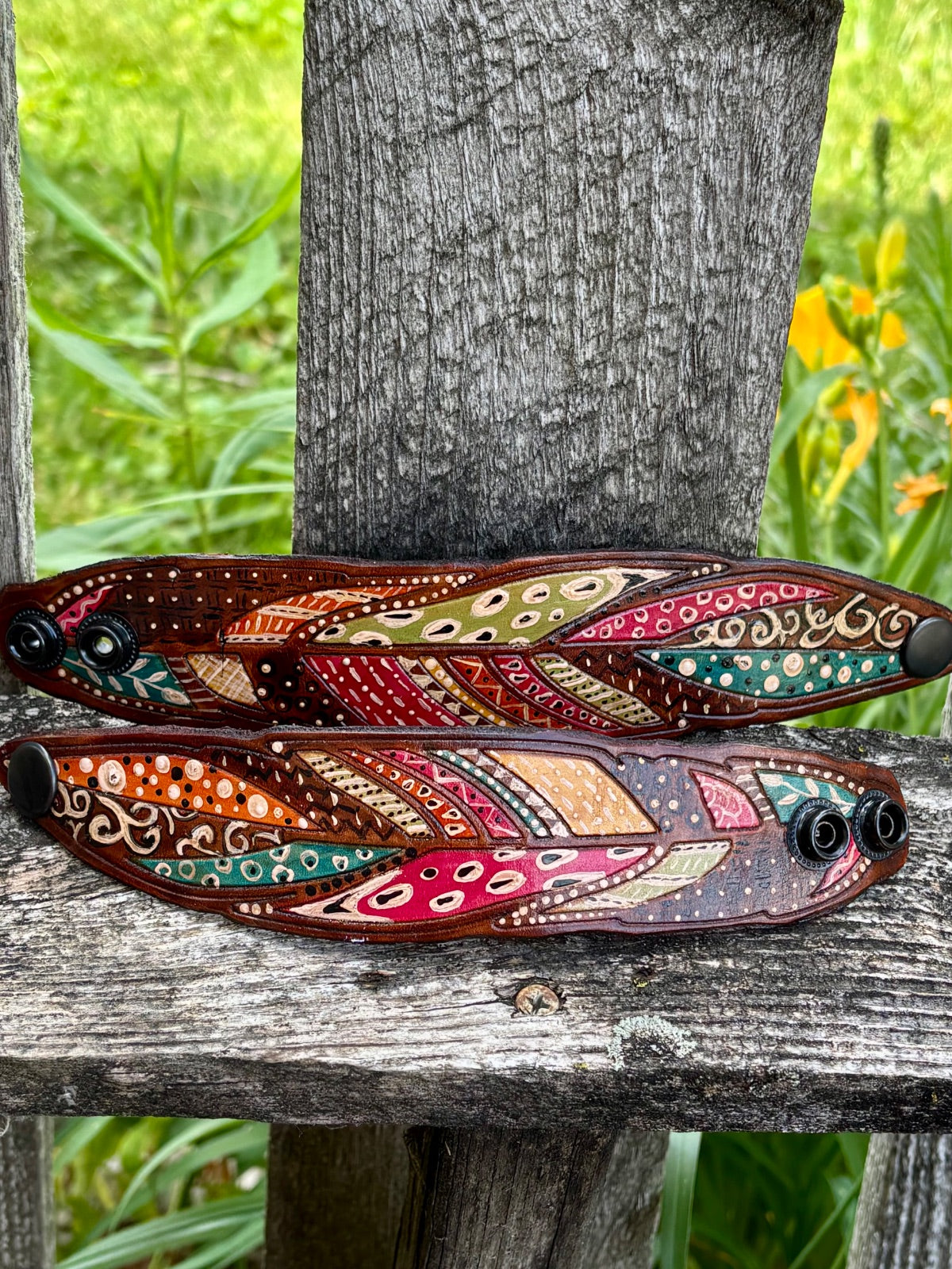 Tribal feather leather cuff bracelet showing snap closure detail, mens fit