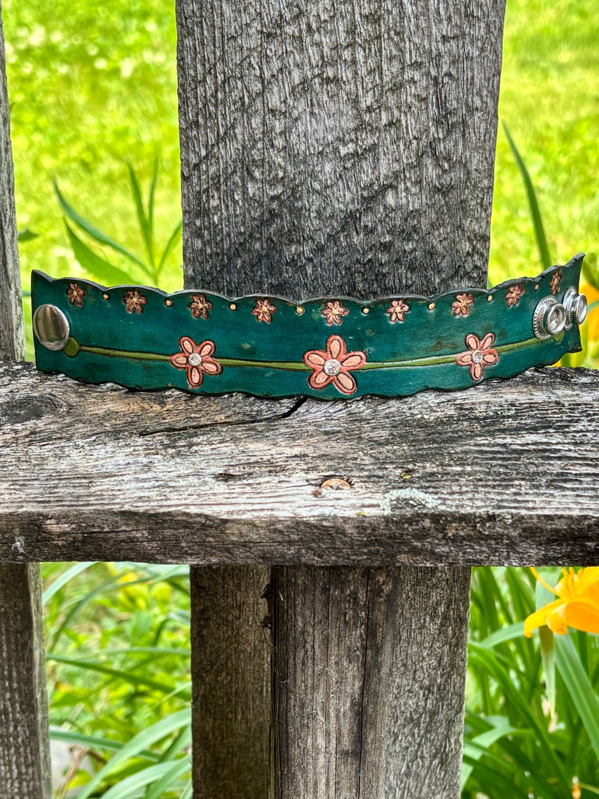 Teal floral leather cuff bracelet close-up showing rhinestone and snap detail
