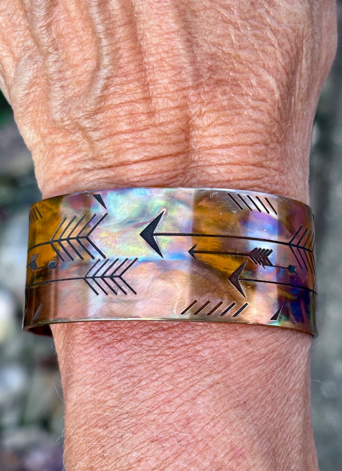 Fire painted copper cuff bracelet worn on wrist