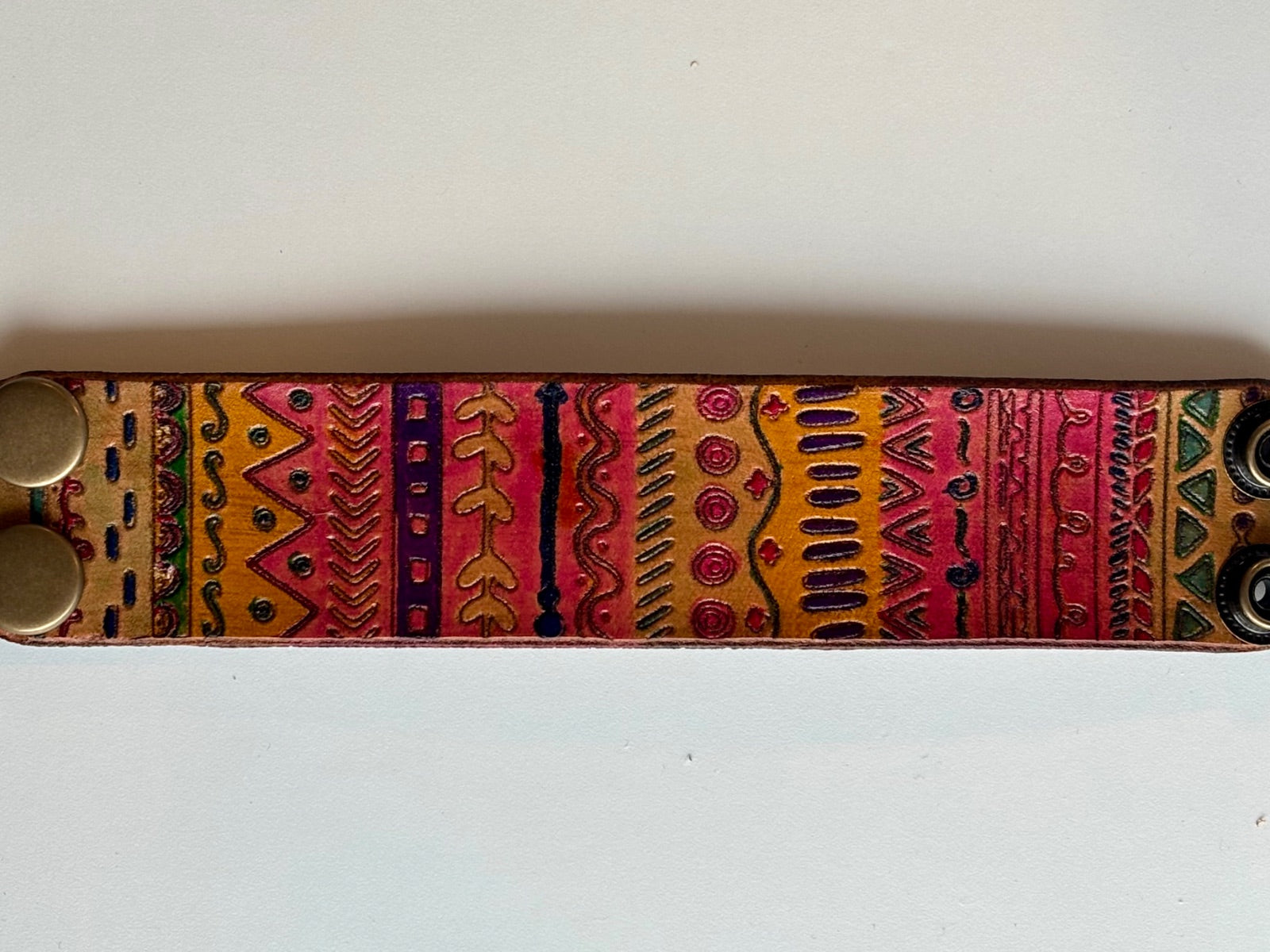 Wide tribal leather cuff bracelet laid flat showing full hand-painted pattern