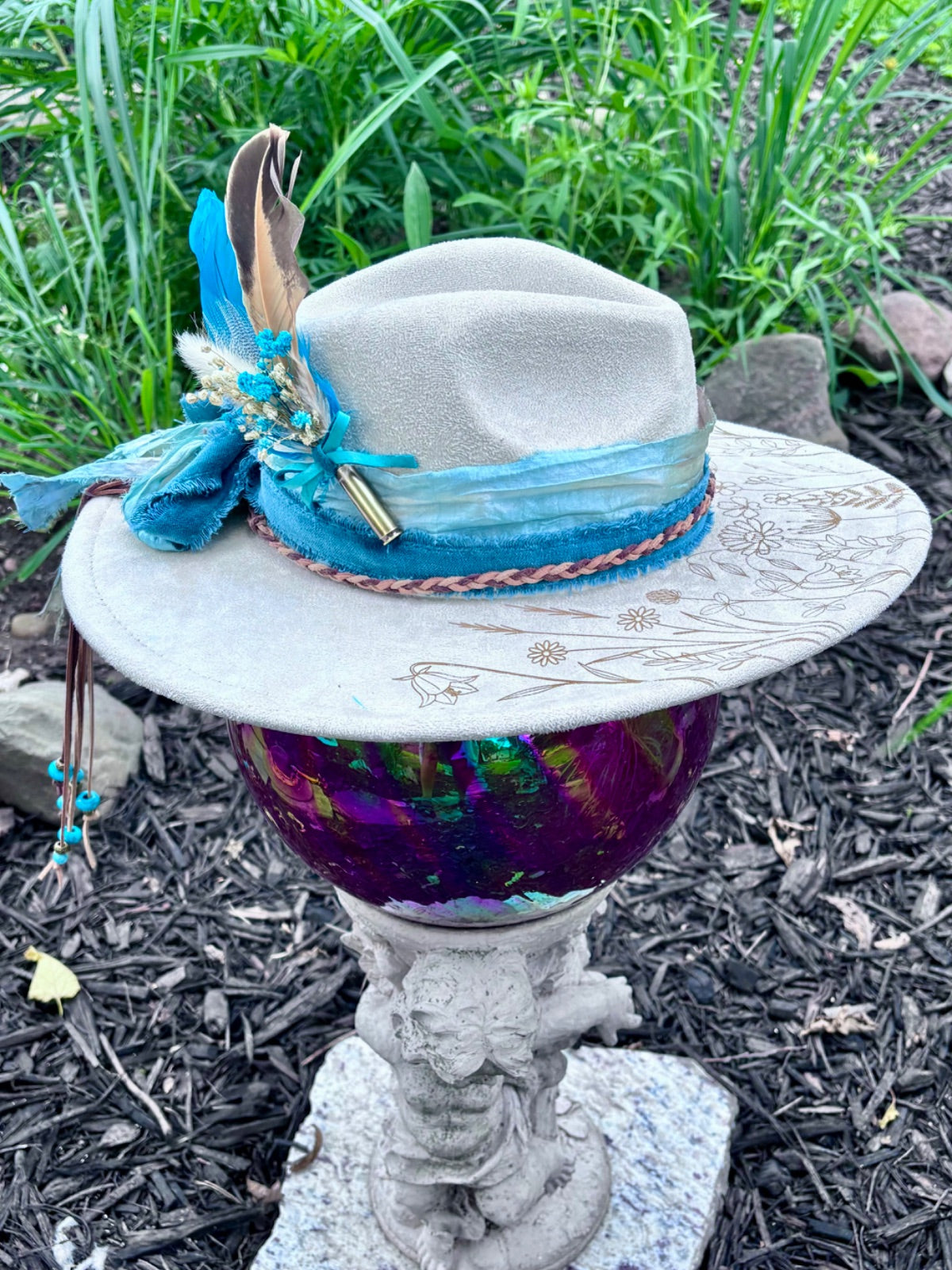 Bullet casing accent with feathers and dried florals on dandelion hat