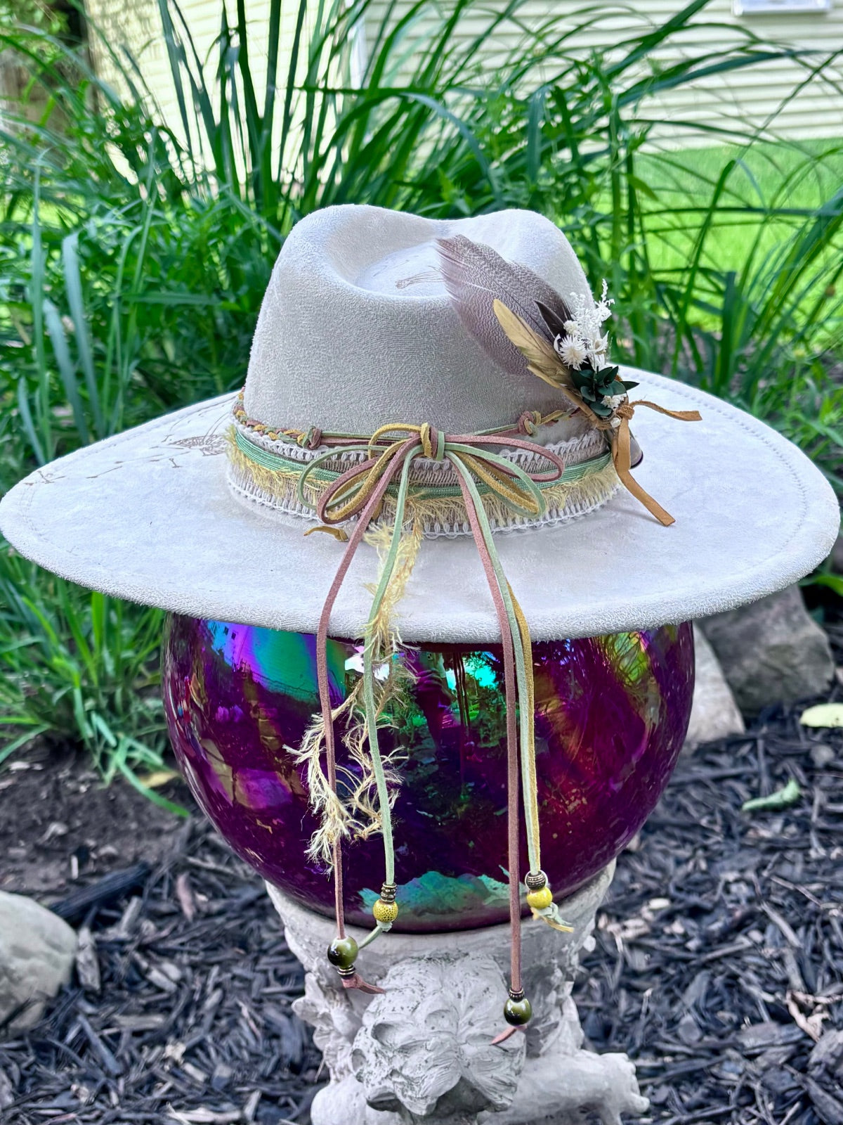 Bullet casing accent with feathers and dried florals on dandelion hat