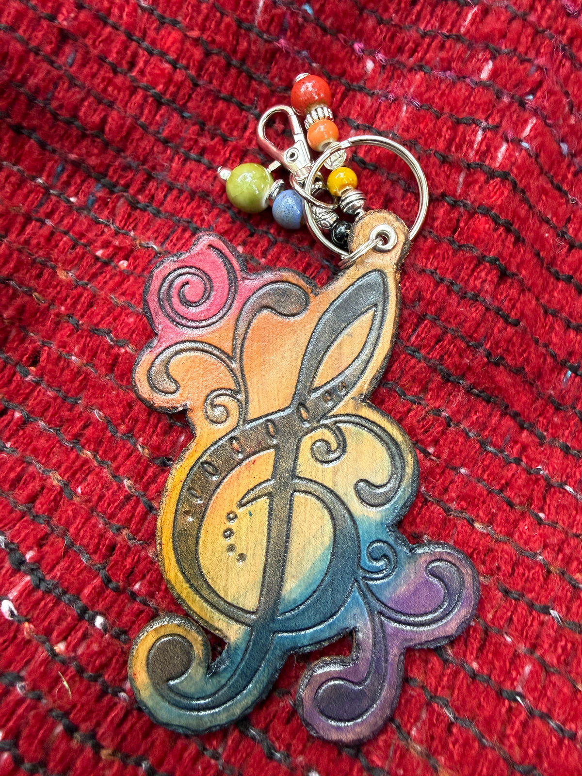 Hand-tooled leather treble clef bag charm in rainbow ombre