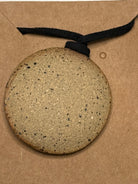 Round stone or ceramic item on a brown paper bag with 'No Mud No Lotus' branding.