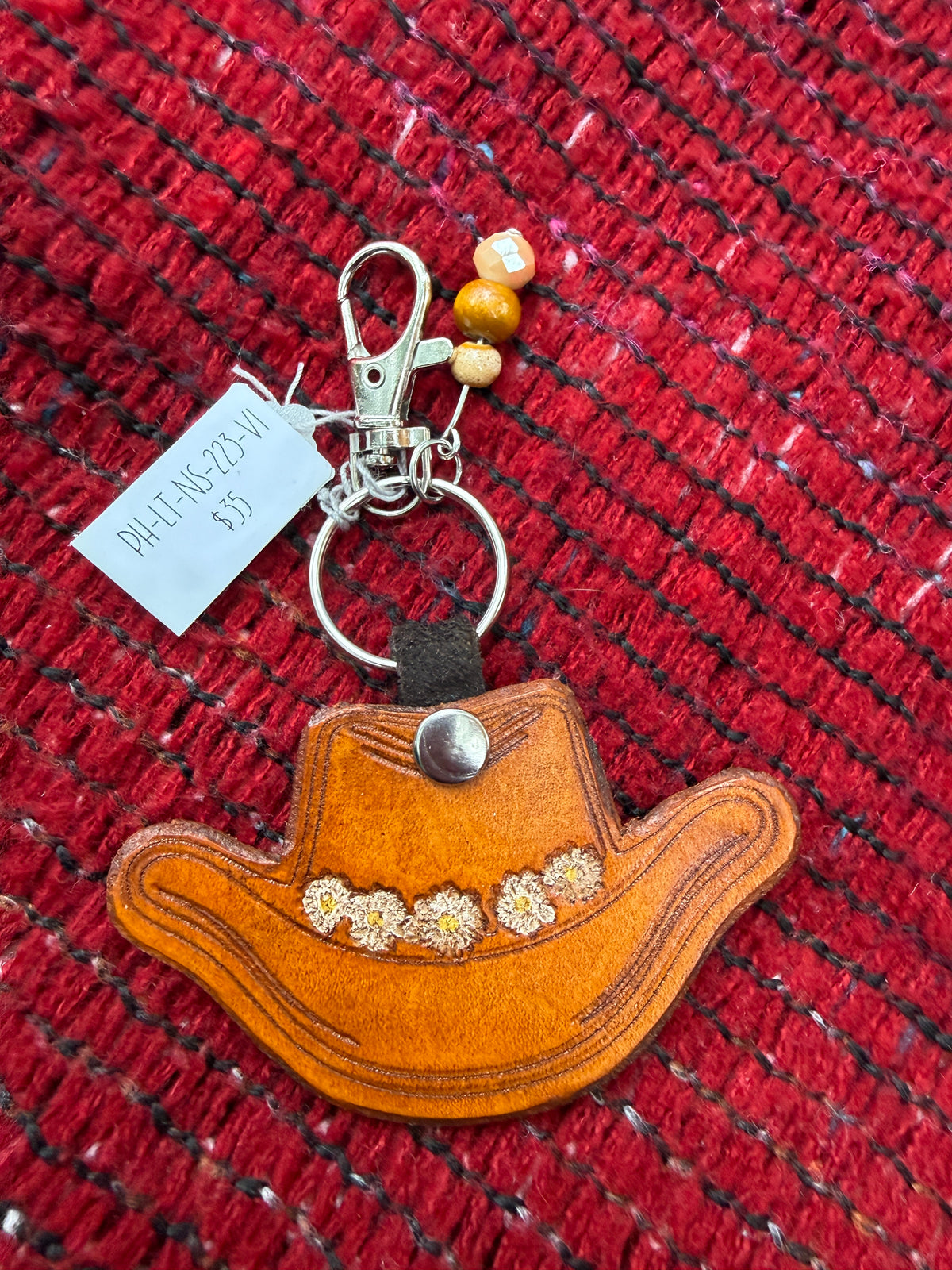 Hand-tooled leather cowboy hat bag charm with daisy chain design