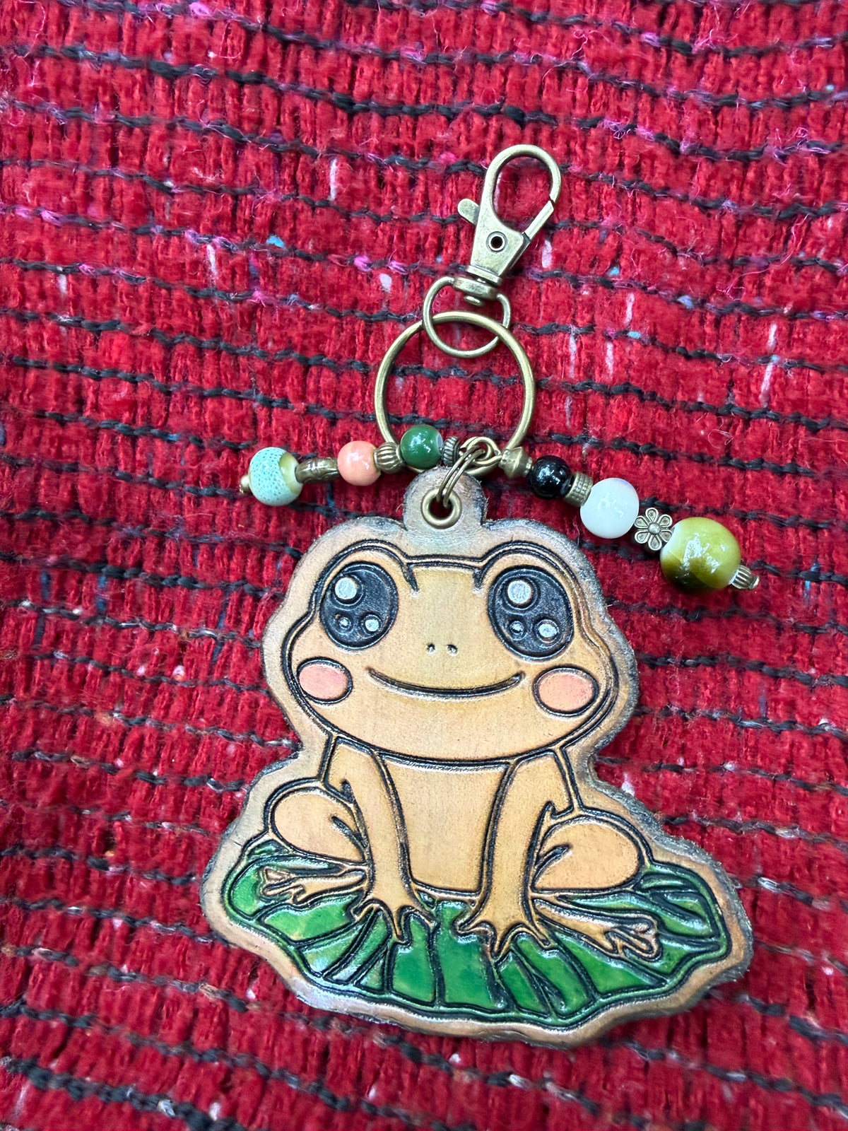 Hand-tooled leather frog bag charm on a lily pad