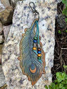 Large hand-tooled leather peacock feather bag charm with wood beads by Angie Meyers Designs