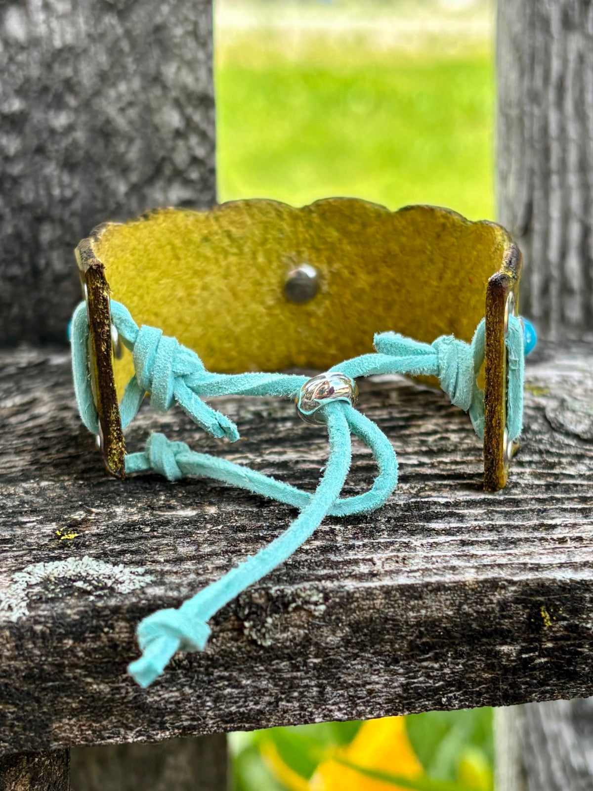 Olive leather cuff bracelet showing turquoise suede lace-tie closure