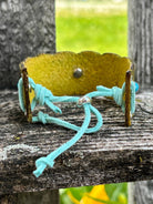 Olive leather cuff bracelet showing turquoise suede lace-tie closure