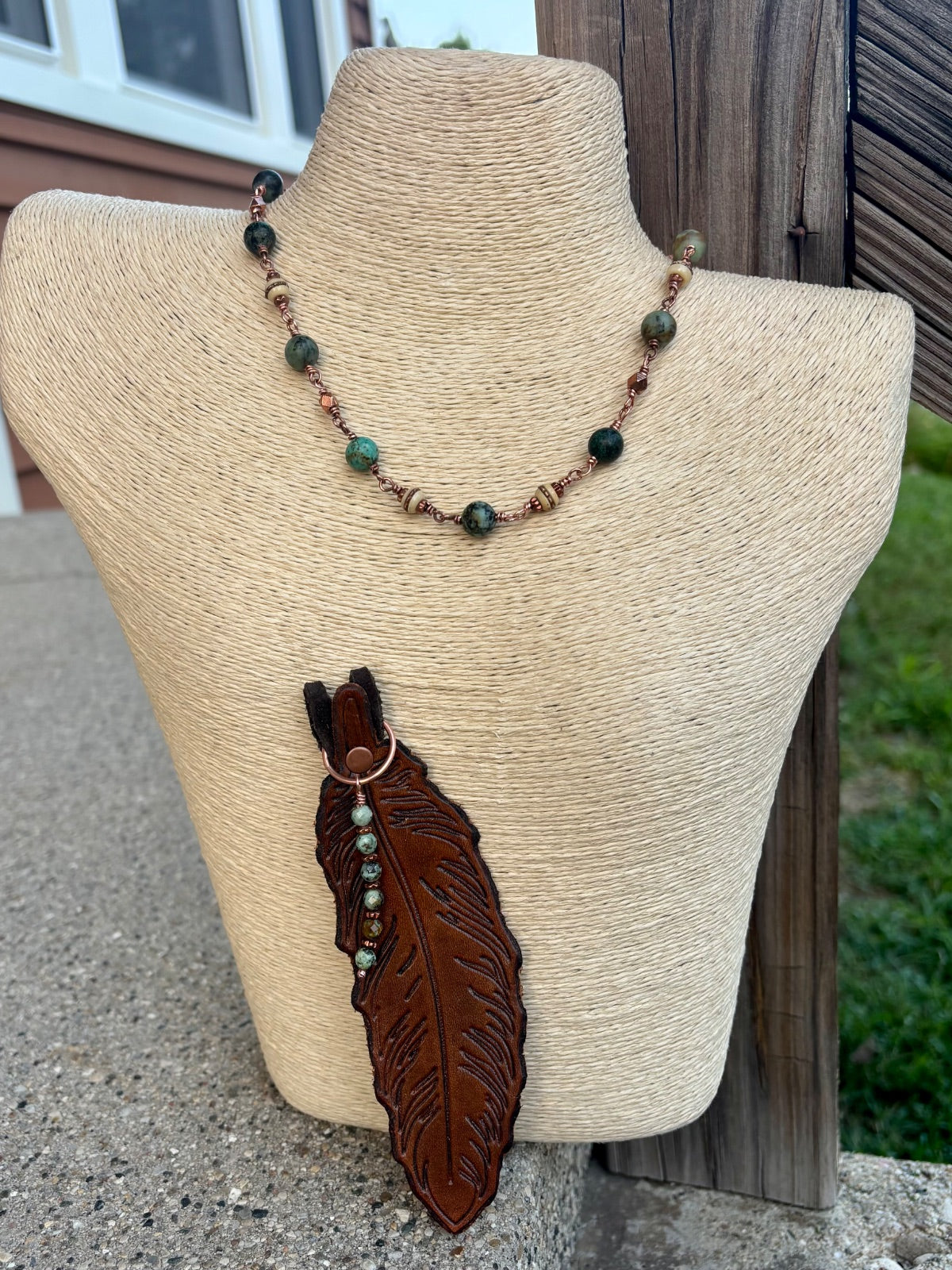 Close-up of embossed leather feather pendant with African turquoise