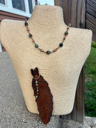 Close-up of embossed leather feather pendant with African turquoise