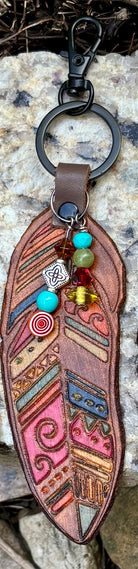 Tribal feather leather bag charm clipped to a keyring, showing beaded dangle detail