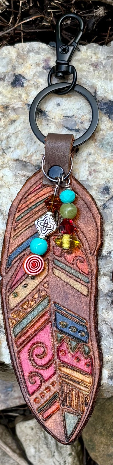 Tribal feather leather bag charm clipped to a keyring, showing beaded dangle detail