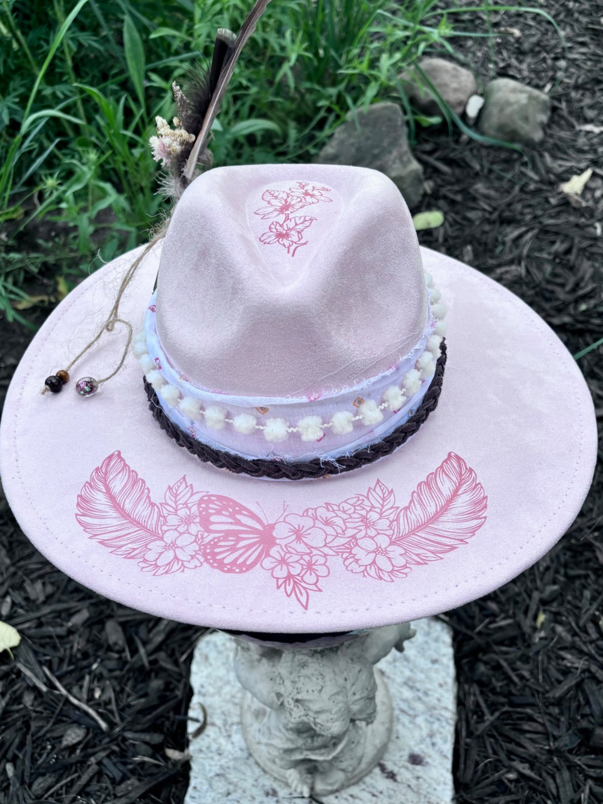 Side view of pink butterfly and feather vegan suede rancher hat