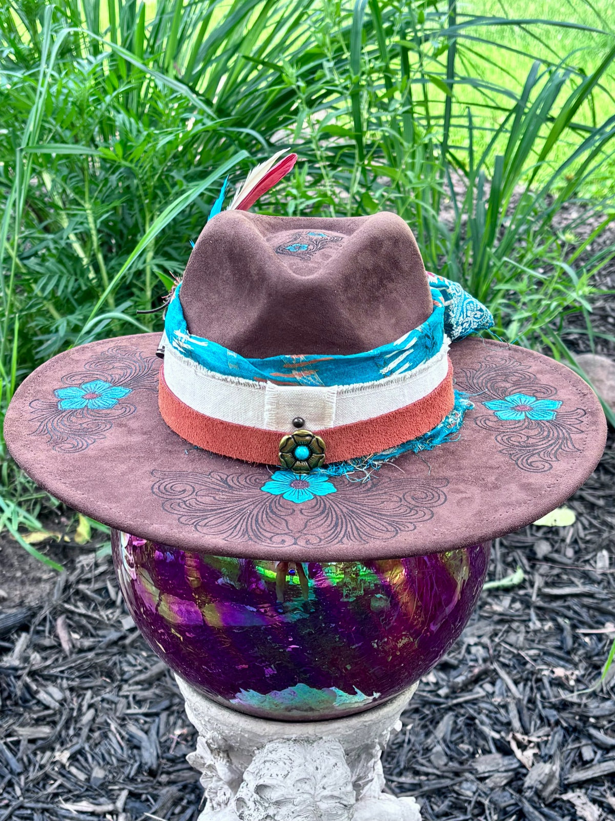 Bullet casing accent with feathers and dried florals on turquoise flower hat