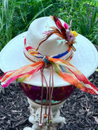 Bullet casing accent with feathers and dried florals on wildflower hat