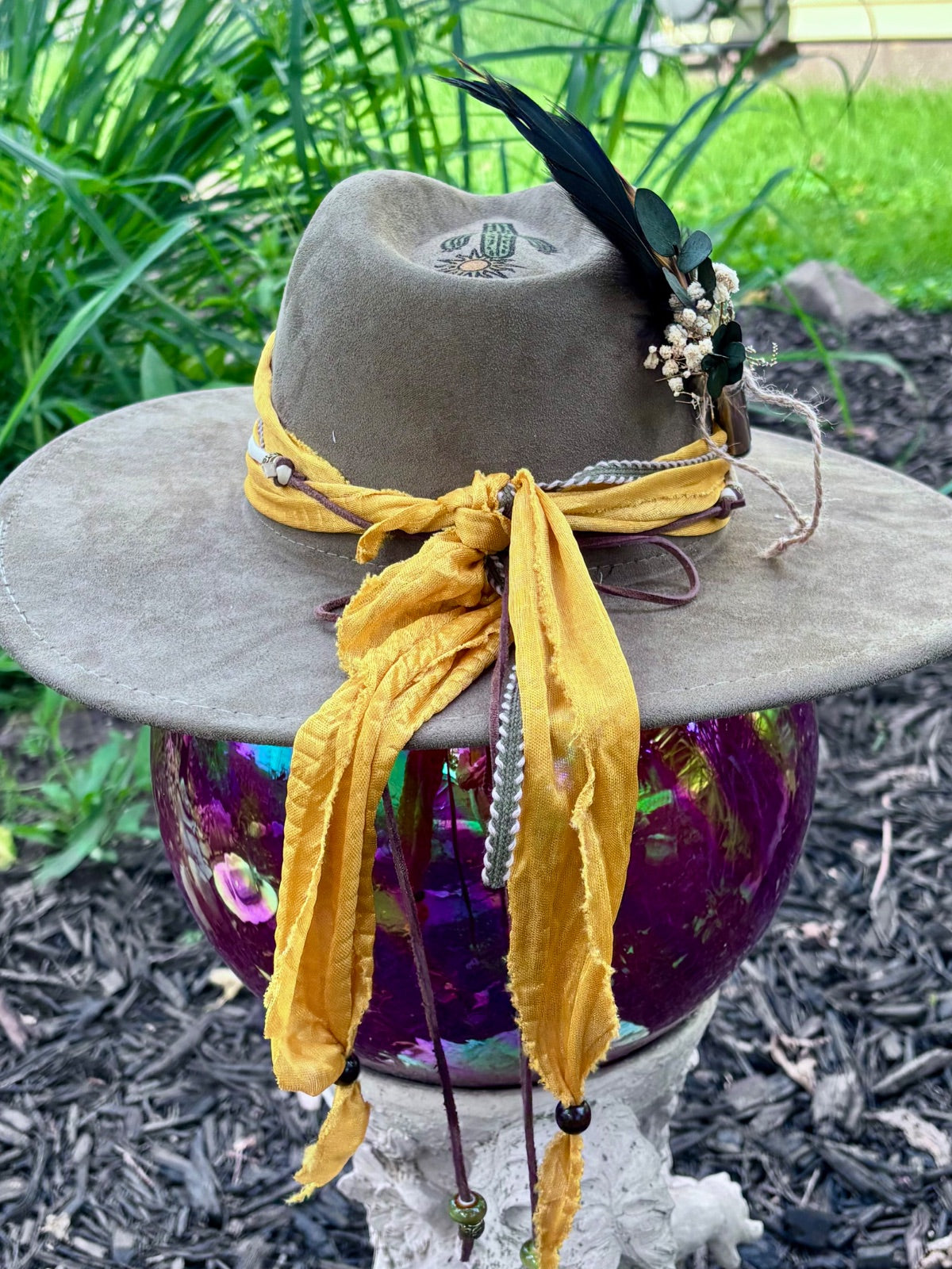 Bullet casing accent with feathers and dried florals on cactus hat