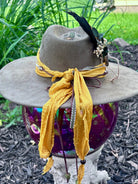 Bullet casing accent with feathers and dried florals on cactus hat
