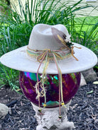 Bullet casing accent with feathers and dried florals on dandelion hat