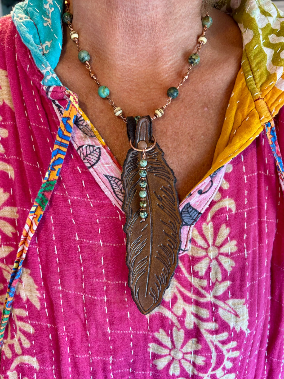 Turquoise leather feather copper necklace styled flat lay