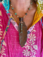 Turquoise leather feather copper necklace styled flat lay