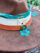Layered hatband detail on turquoise flower rancher hat